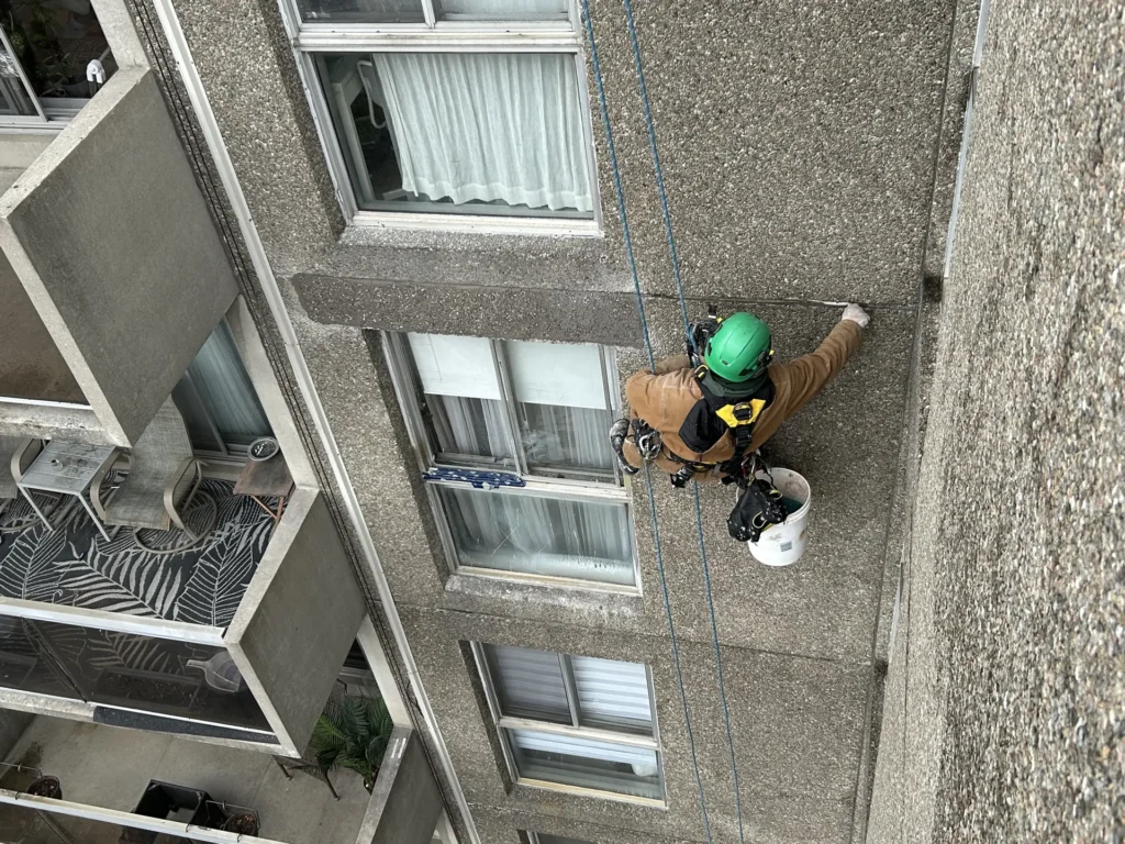 Technicien sur corde réparant une façade d’immeuble